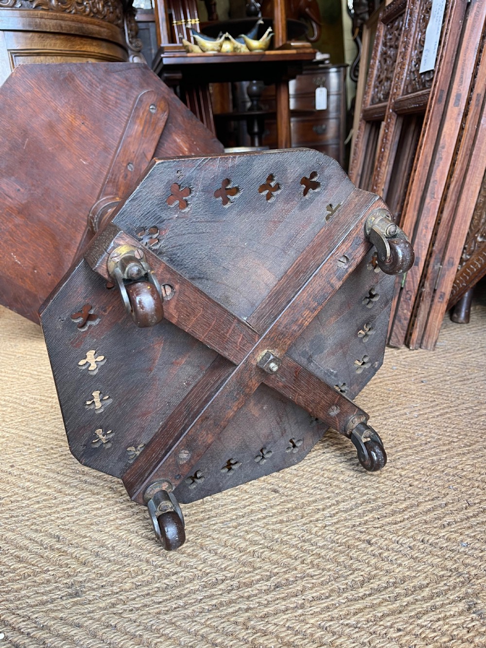 A nineteenth-century dark oak octagonal occasional table featuring a central turned column with carved quatrefoil piercings and a geometric carved base. View V