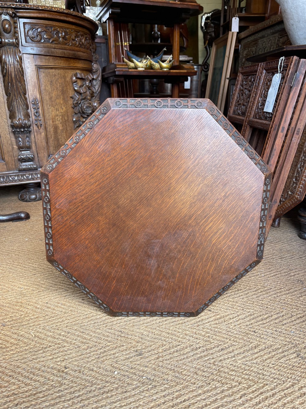 A nineteenth-century dark oak octagonal occasional table featuring a central turned column with carved quatrefoil piercings and a geometric carved base. View VI