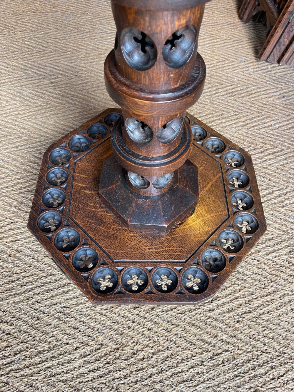 A nineteenth-century dark oak octagonal occasional table featuring a central turned column with carved quatrefoil piercings and a geometric carved base. View VII