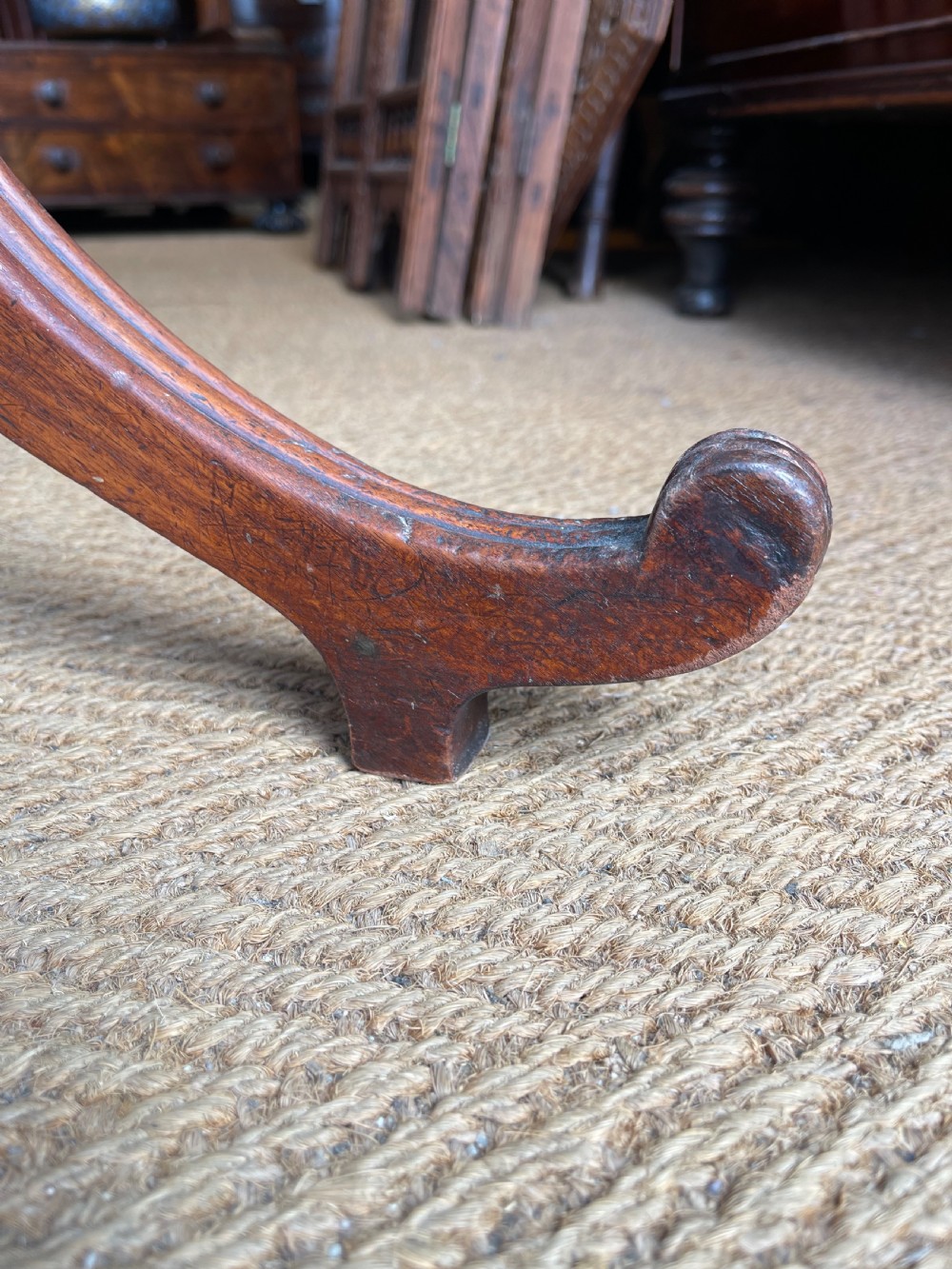 A Georgian mahogany tilt top table displayed vertically, featuring a rectangular top, turned central column, and reeded tripod legs. View VI