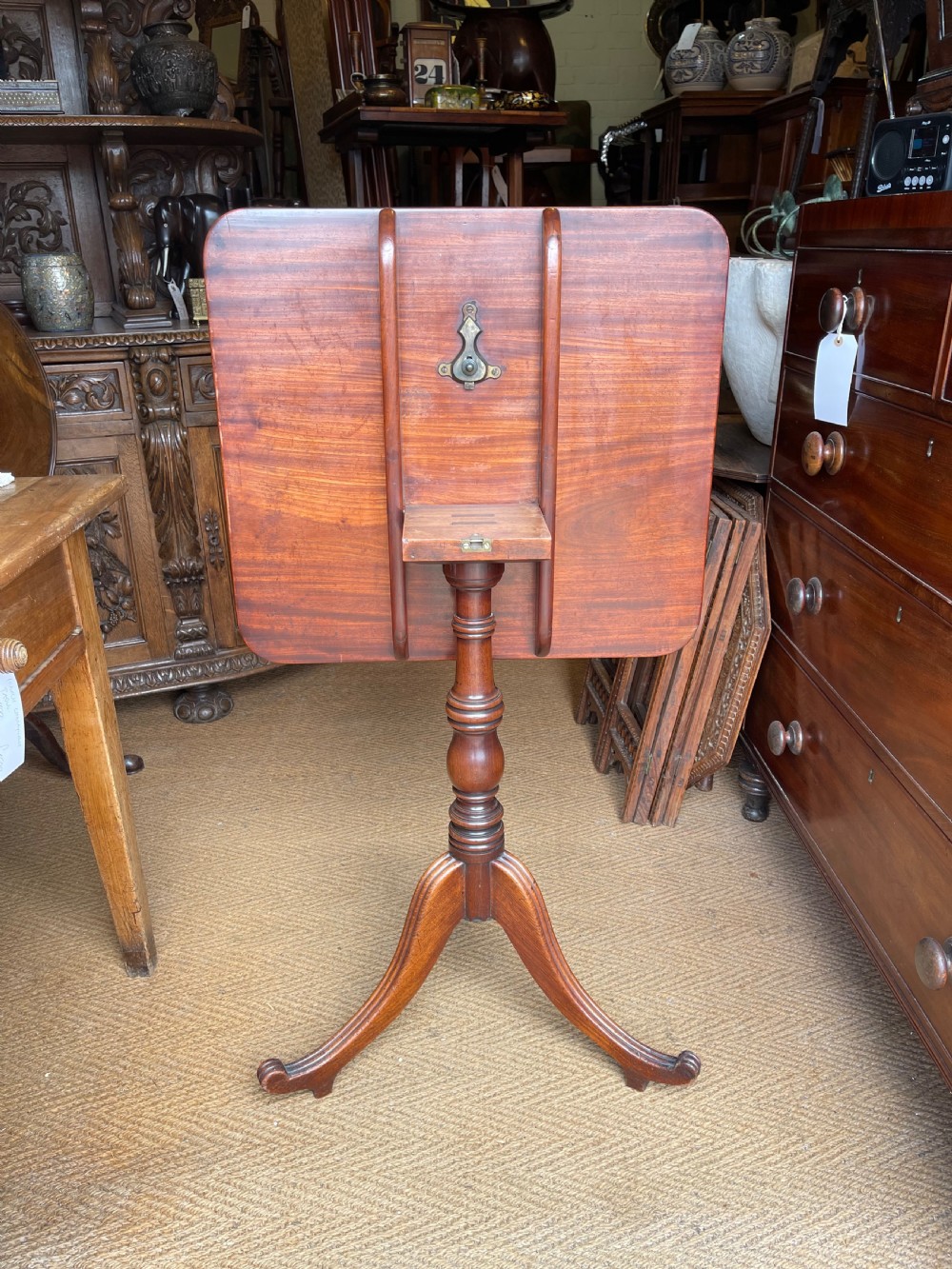 A Georgian mahogany tilt top table displayed vertically, featuring a rectangular top, turned central column, and reeded tripod legs. View VII