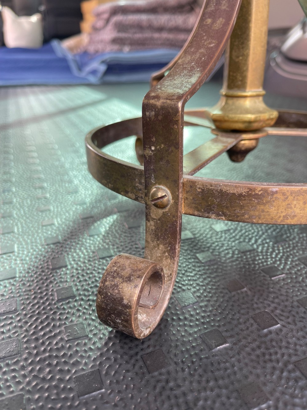 A nineteenth-century adjustable gilt brass standtable featuring a circular top, central column with a screw adjustment key, and scrolled tripod base. View VIII