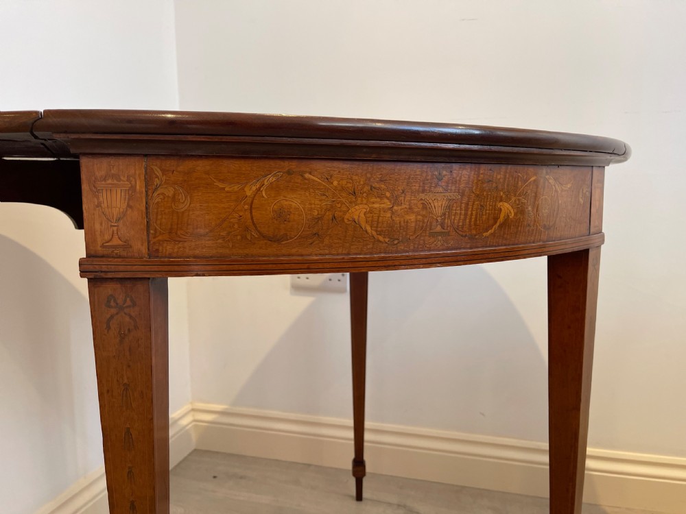 An oval antique mahogany Pembroke table with detailed marquetry inlay, drop leaves, and tapered legs. View II