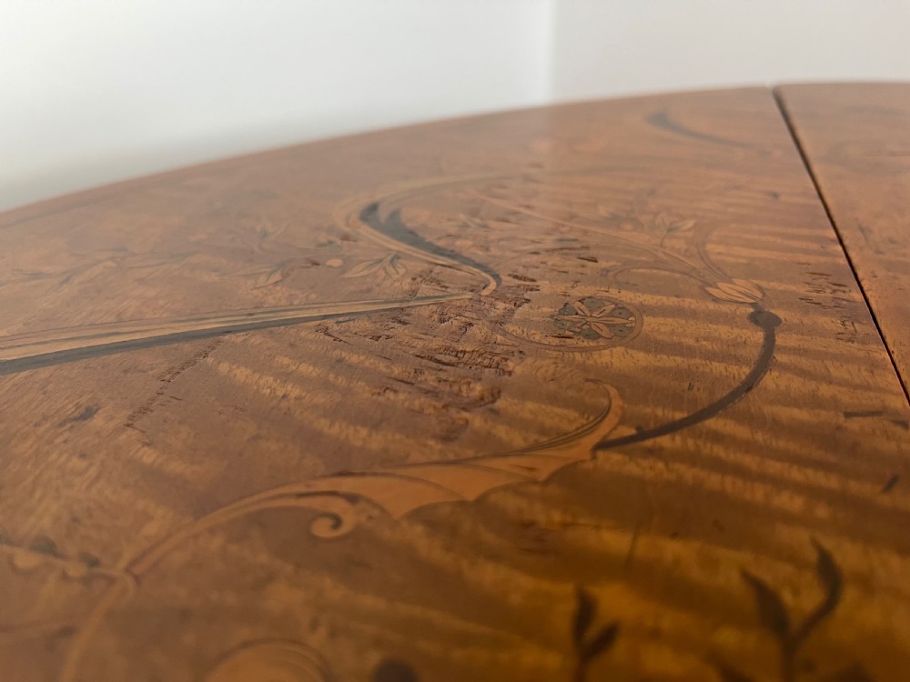 An oval antique mahogany Pembroke table with detailed marquetry inlay, drop leaves, and tapered legs. View VIII