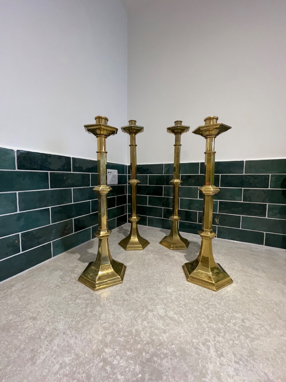 Group of four tall brass candlesticks 