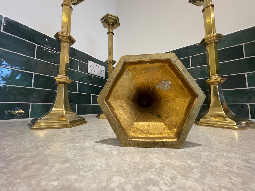 Group of four tall brass candlesticks  View II