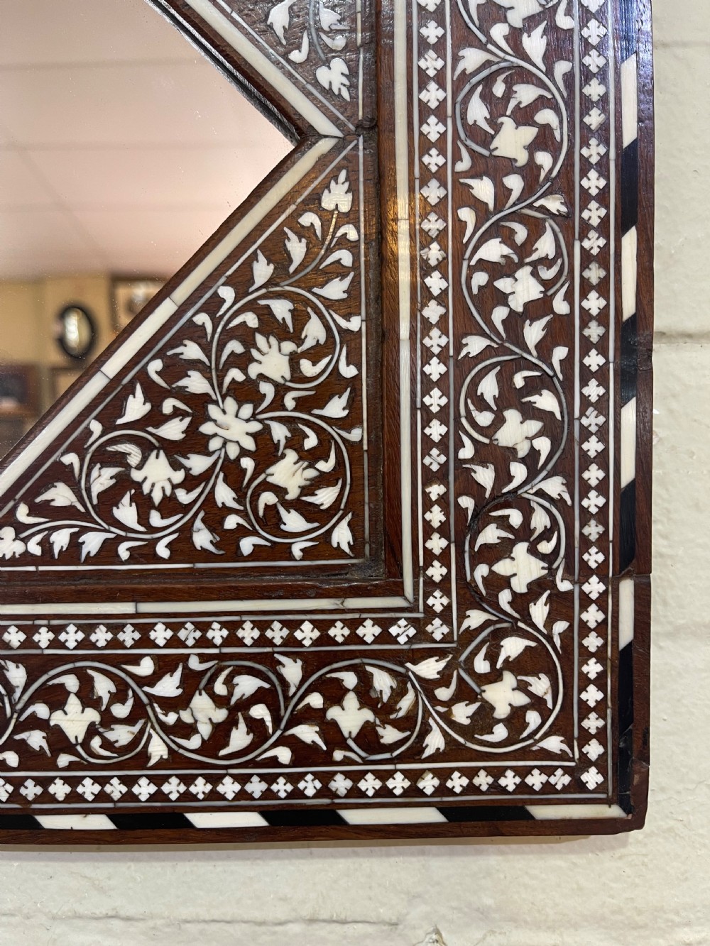 A square dark wood Anglo-Indian Hoshiarpur mirror featuring intricate bone inlay floral scrollwork surrounding a diamond-shaped central glass aperture. View II