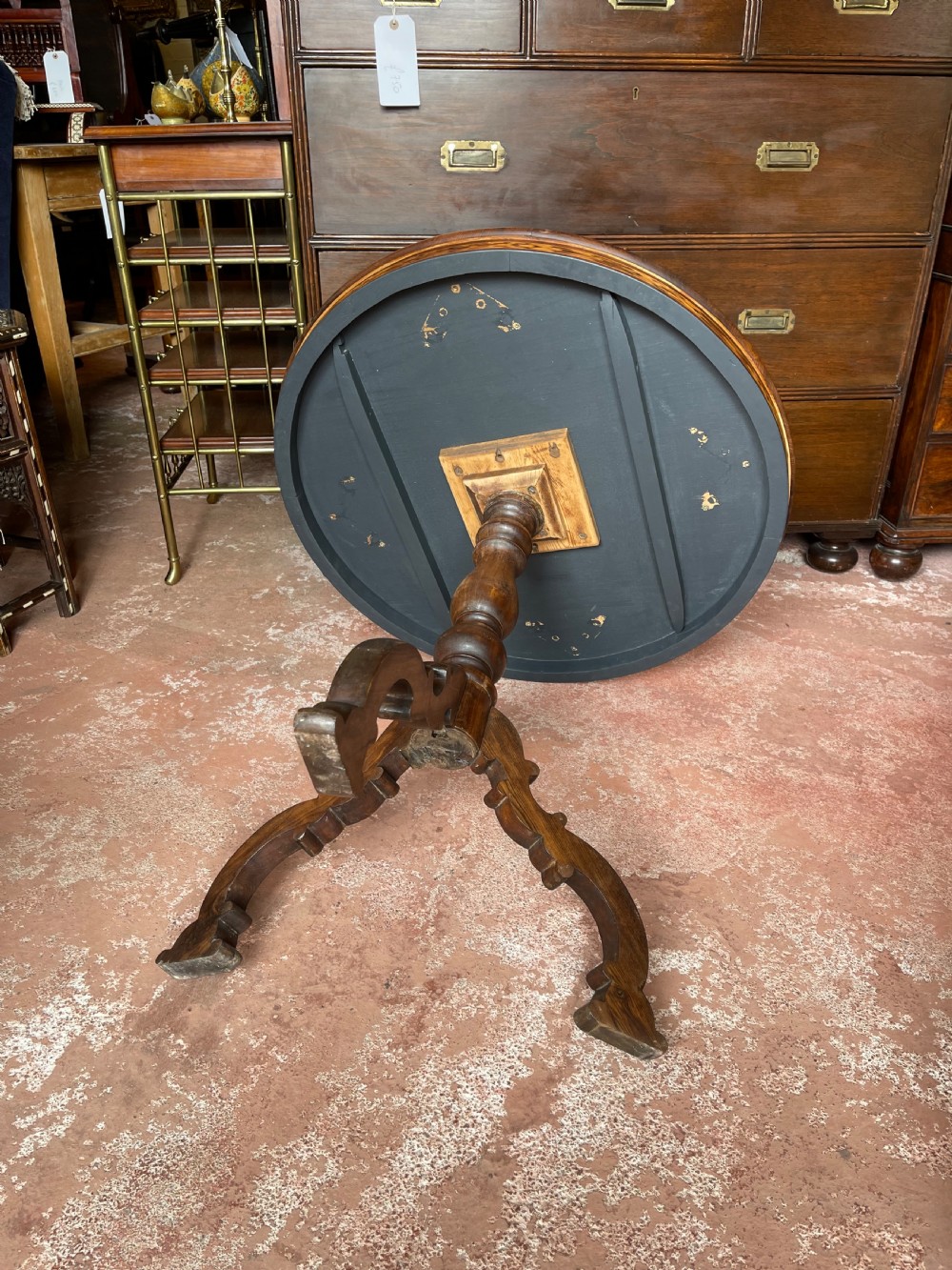 A nineteenth-century circular wooden table with a central starburst marquetry top, floral border, turned pedestal, and tripod legs. View IV