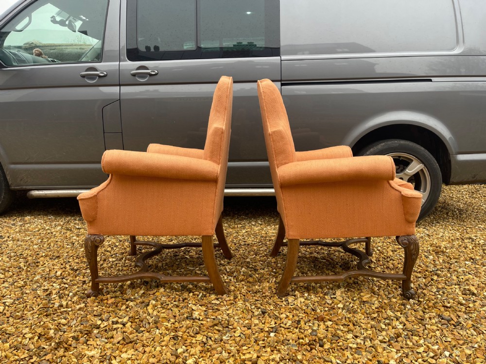 A pair of high-backed armchairs upholstered in textured orange fabric with intricate carved walnut legs and serpentine stretchers. View III