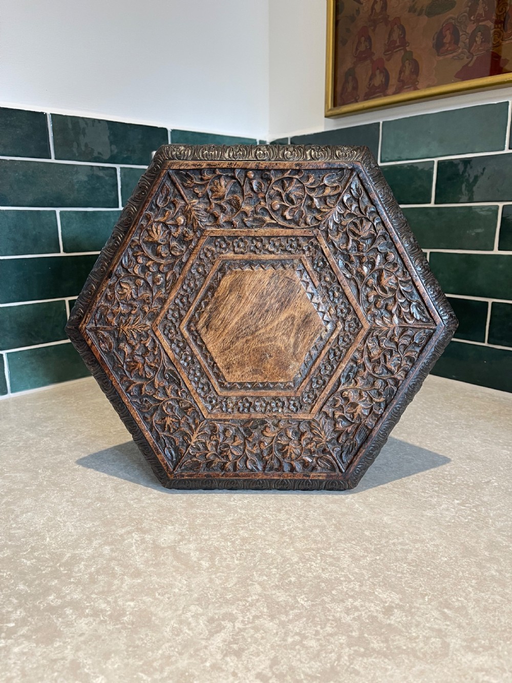 An octagonal dark wood side table with intricate hand-carved foliate patterns and openwork lattice panels on the base. View II