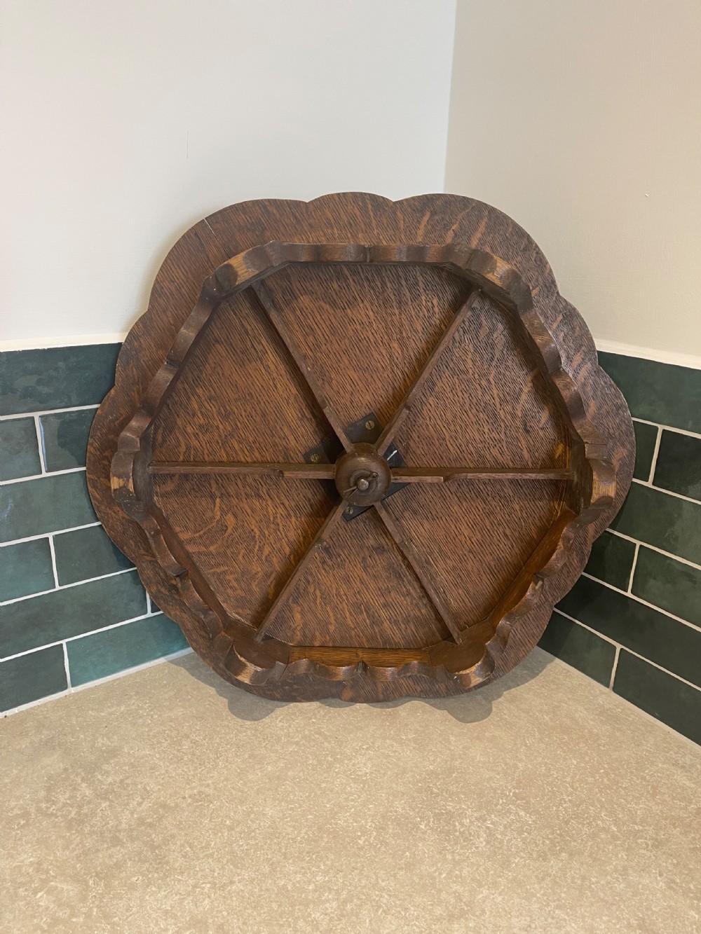 A circular carved oak Lazy Susan featuring six outer recessed circular compartments, one central compartment, and a floral carved scalloped border. View V