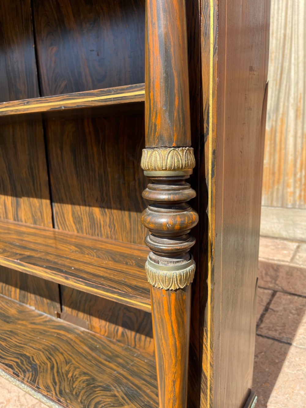 An early nineteenth-century open bookcase featuring a simulated rosewood painted finish, green marble top, gilt star motifs, and turned side columns. View VI