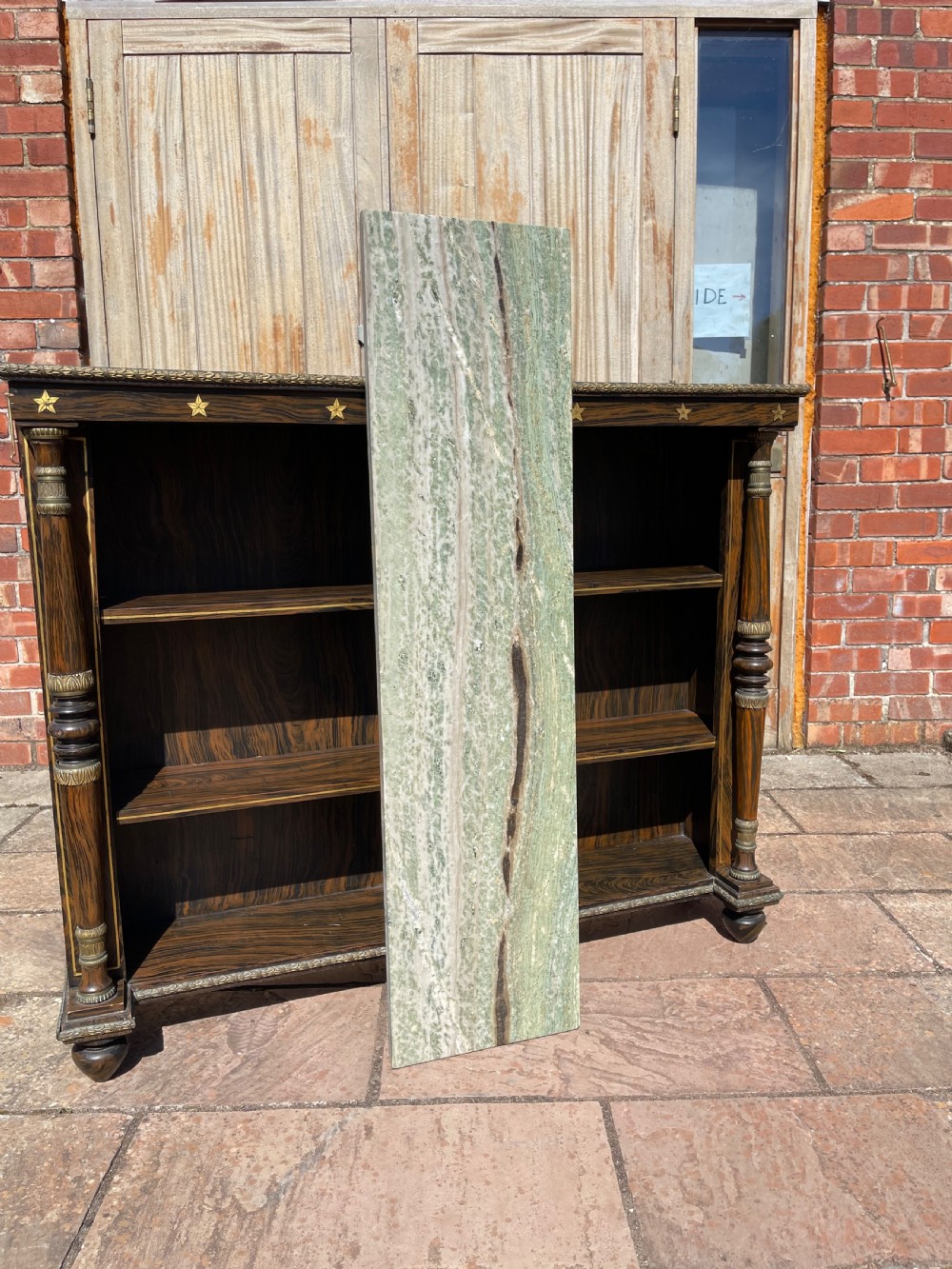 An early nineteenth-century open bookcase featuring a simulated rosewood painted finish, green marble top, gilt star motifs, and turned side columns. View VIII
