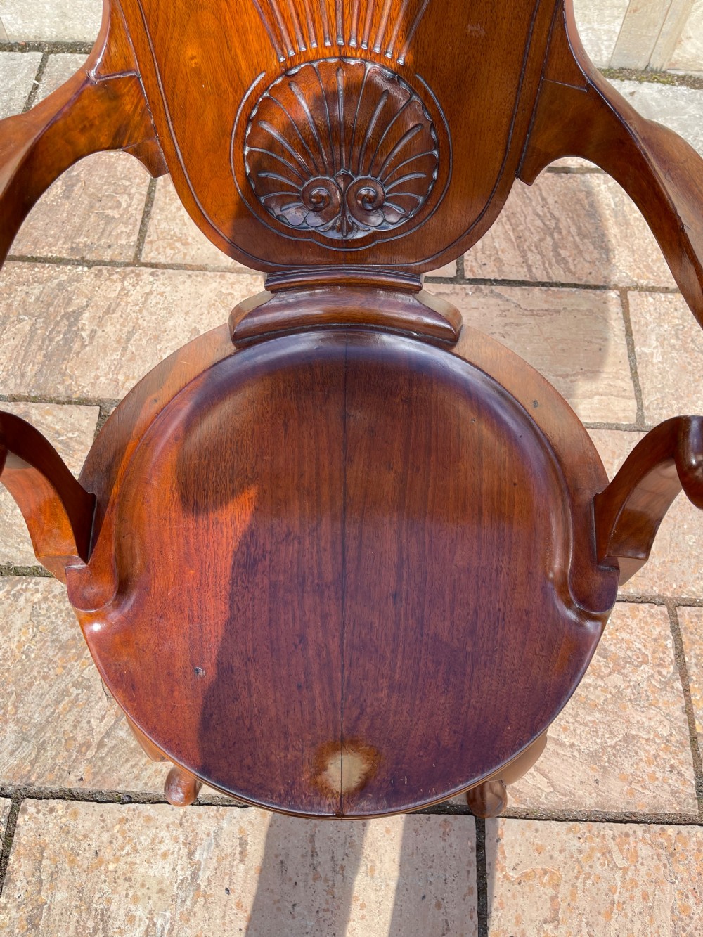 A late nineteenth-century carved mahogany revolving desk chair featuring a shell-carved backrest, curved armrests, a contoured wooden seat, and cabriole legs. View III