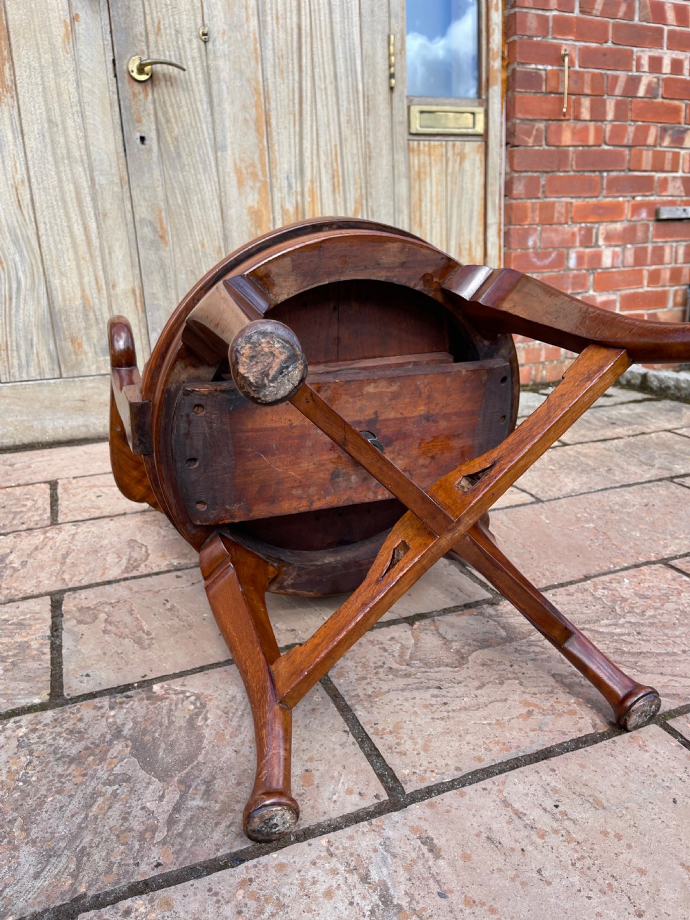 A late nineteenth-century carved mahogany revolving desk chair featuring a shell-carved backrest, curved armrests, a contoured wooden seat, and cabriole legs. View V