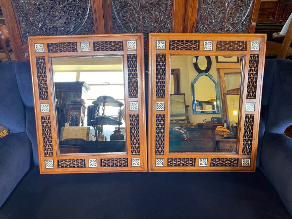 A pair of rectangular wooden wall mirrors featuring Moorish lattice panels and geometric bone inlays.