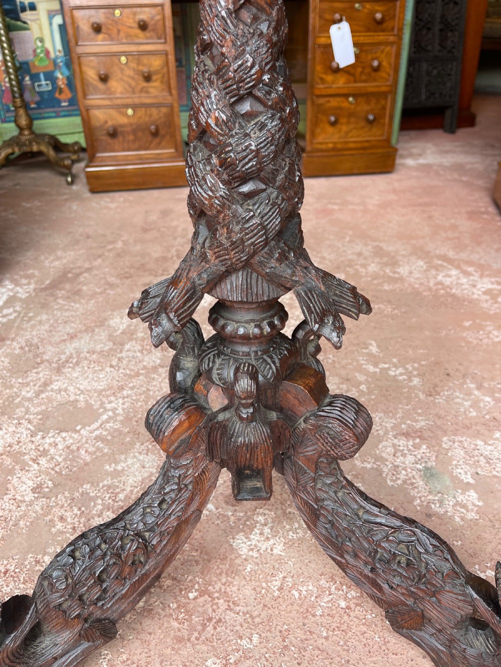 A round wooden pedestal table featuring hand-carved foliate borders and a sculpted tripod base. View III