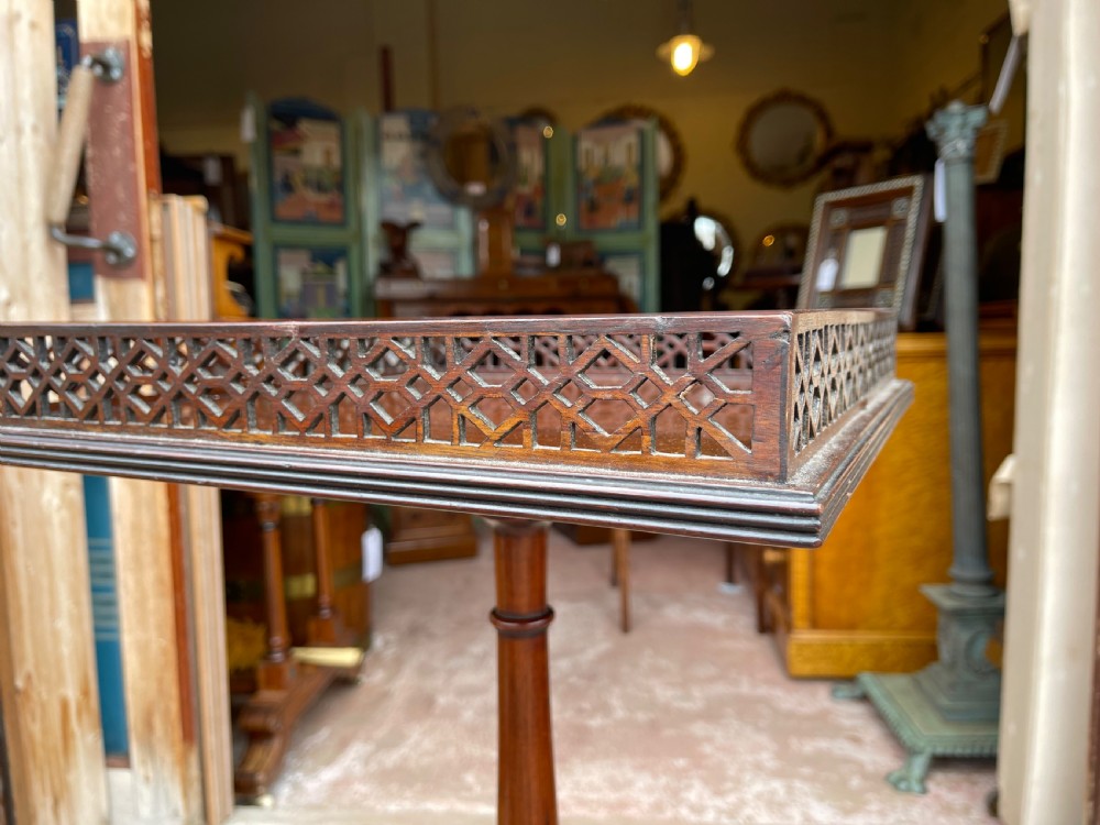 A tall mahogany pedestal side table featuring a square top with a fretwork gallery, a turned stem, and three splayed legs. View II
