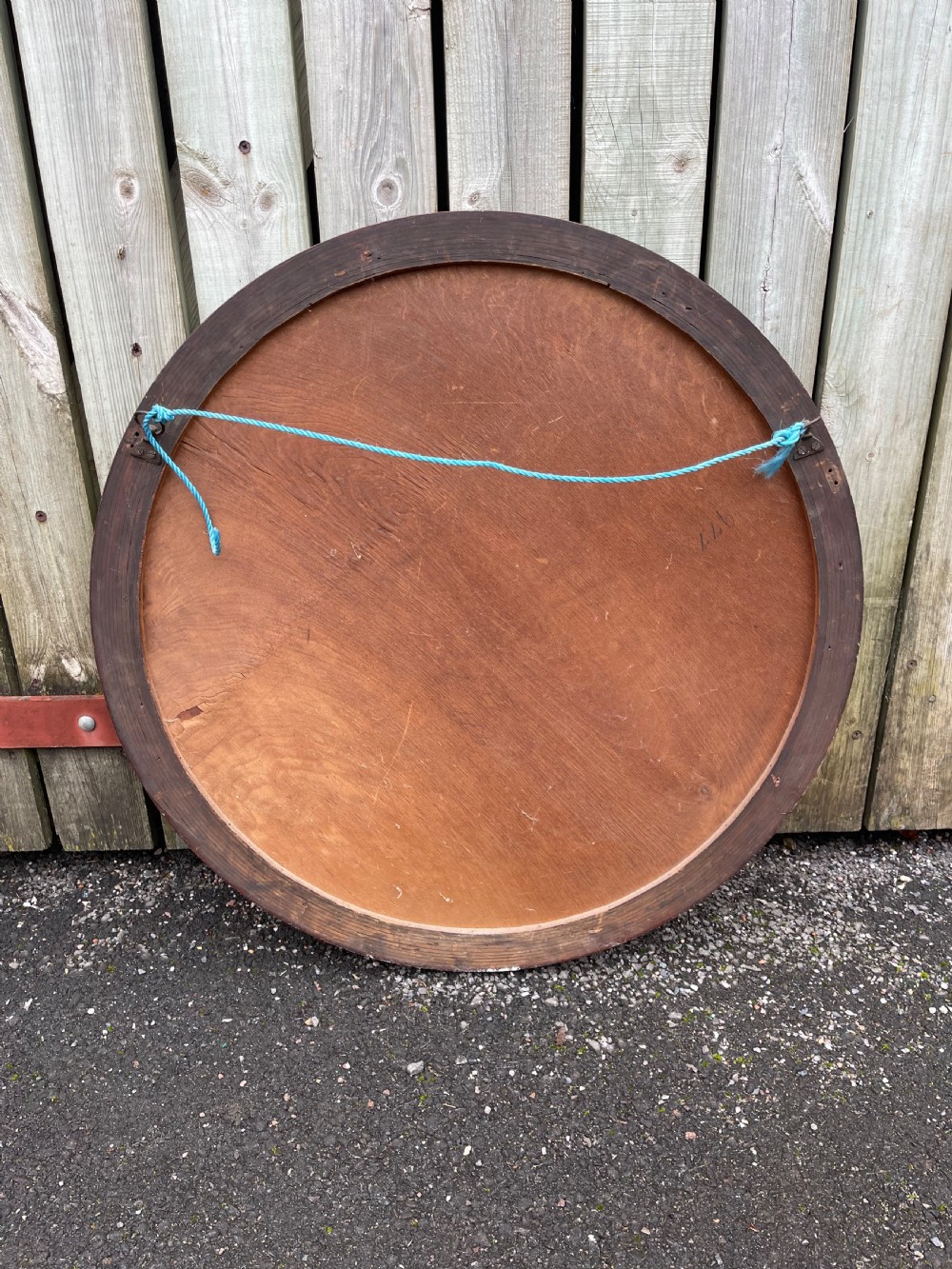 A large circular wall mirror featuring a polished mahogany wooden frame with carved edge detail and a bevelled glass plate. View III