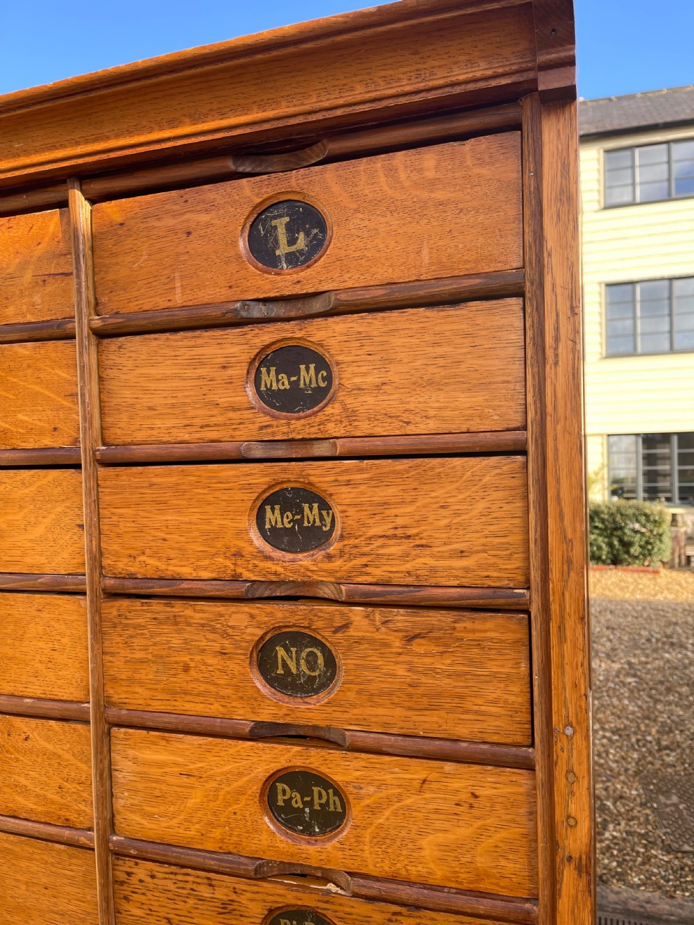A tall Victorian golden oak Amberg patent filing cabinet featuring twin vertical columns of index drawers marked with alphabetical labels. View II