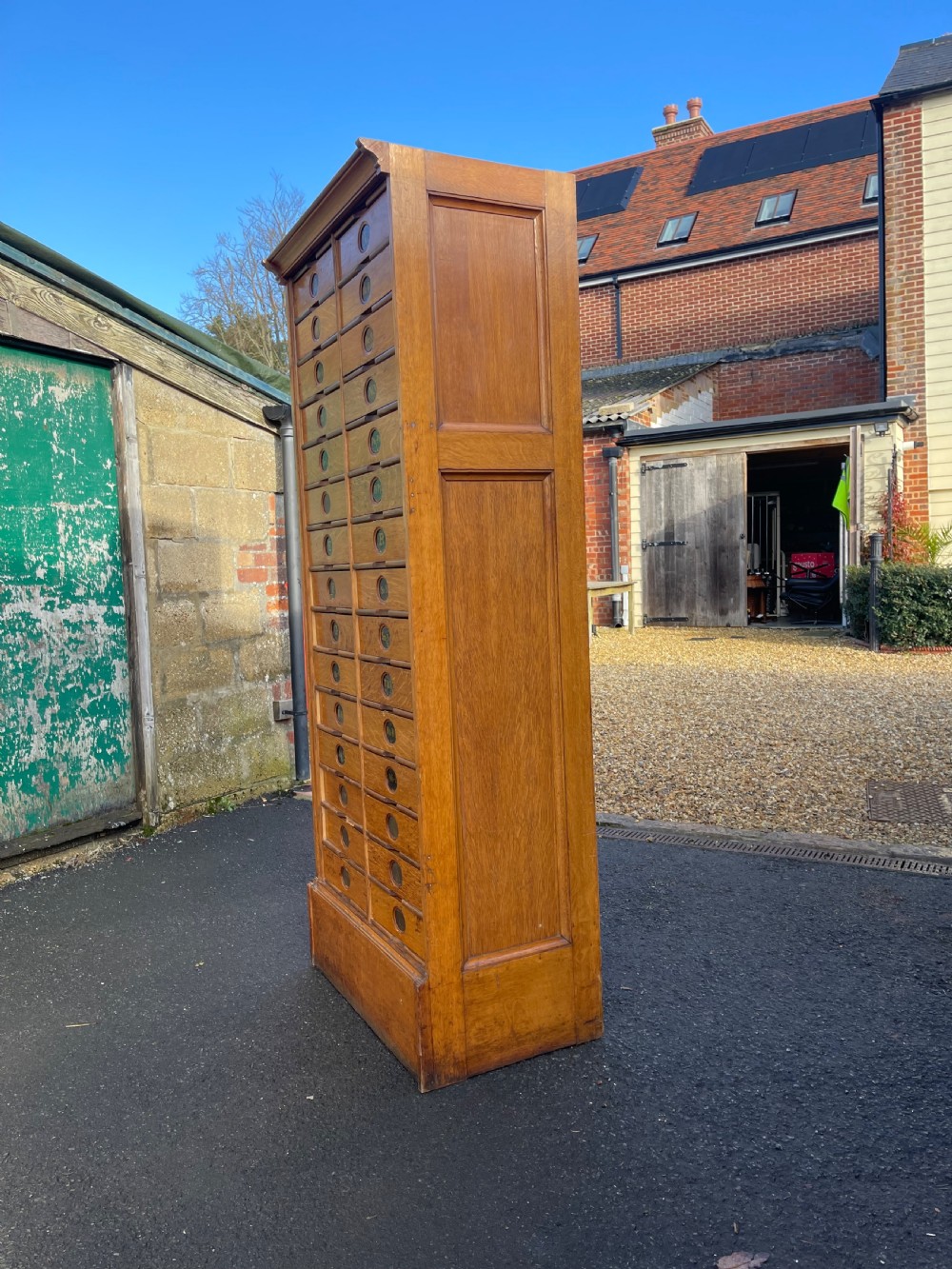 A tall Victorian golden oak Amberg patent filing cabinet featuring twin vertical columns of index drawers marked with alphabetical labels. View V