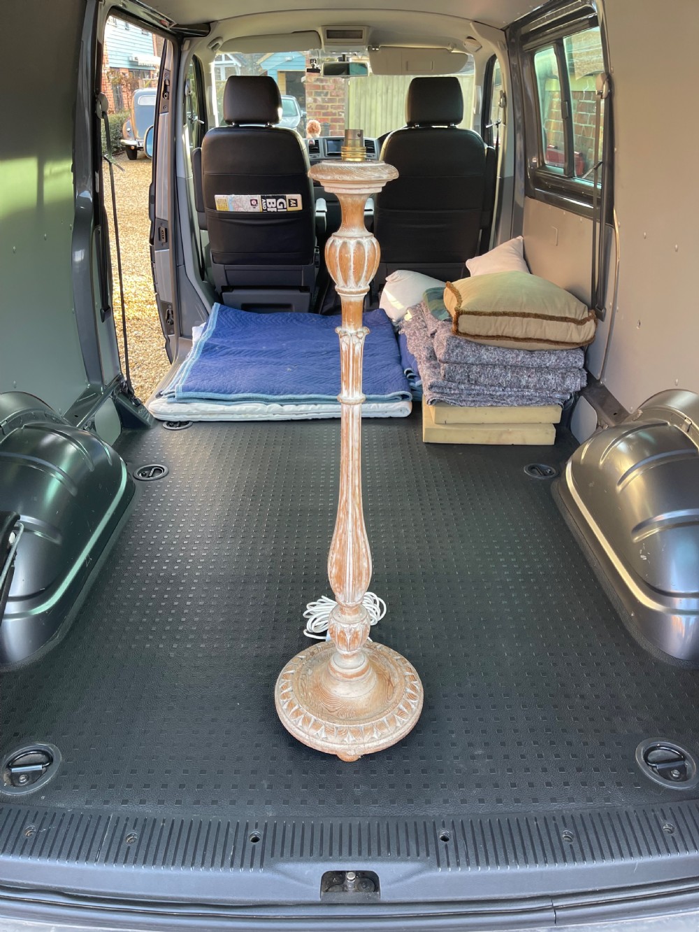 A tall turned and carved pine standard lamp base with a whitewashed natural finish and round carved base.