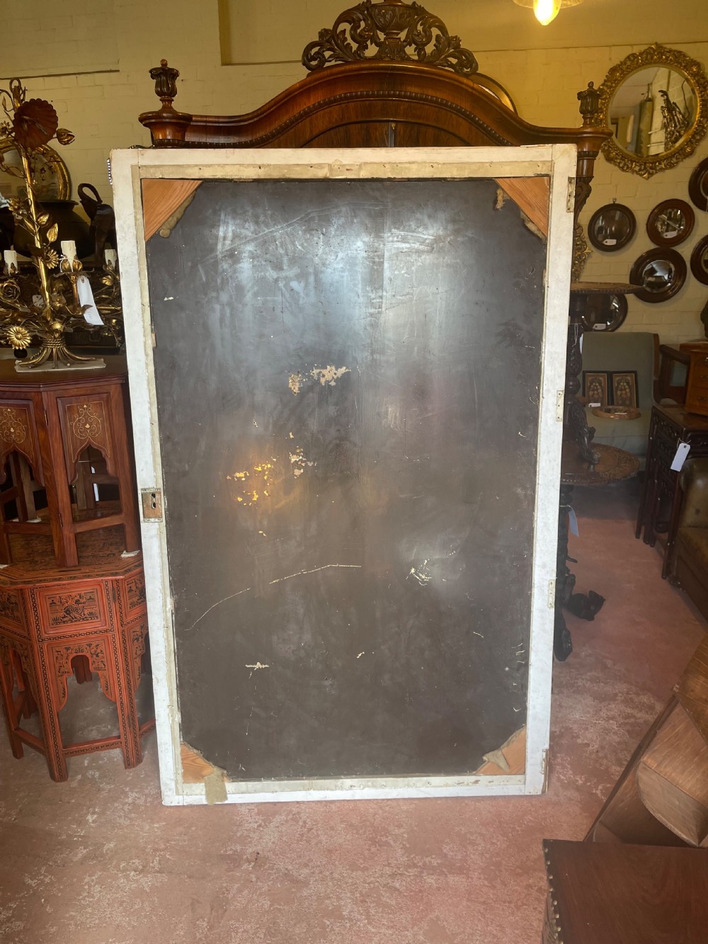 A large rectangular wall mirror featuring a cream-painted wooden frame decorated with a continuous carved Vitruvian scroll wave motif along all four sides. View II