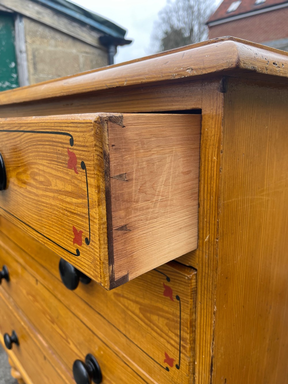 Victorian honey pine chest of drawers featuring two short drawers over three long drawers with dark turned knobs and painted decorative corner accents. View IX