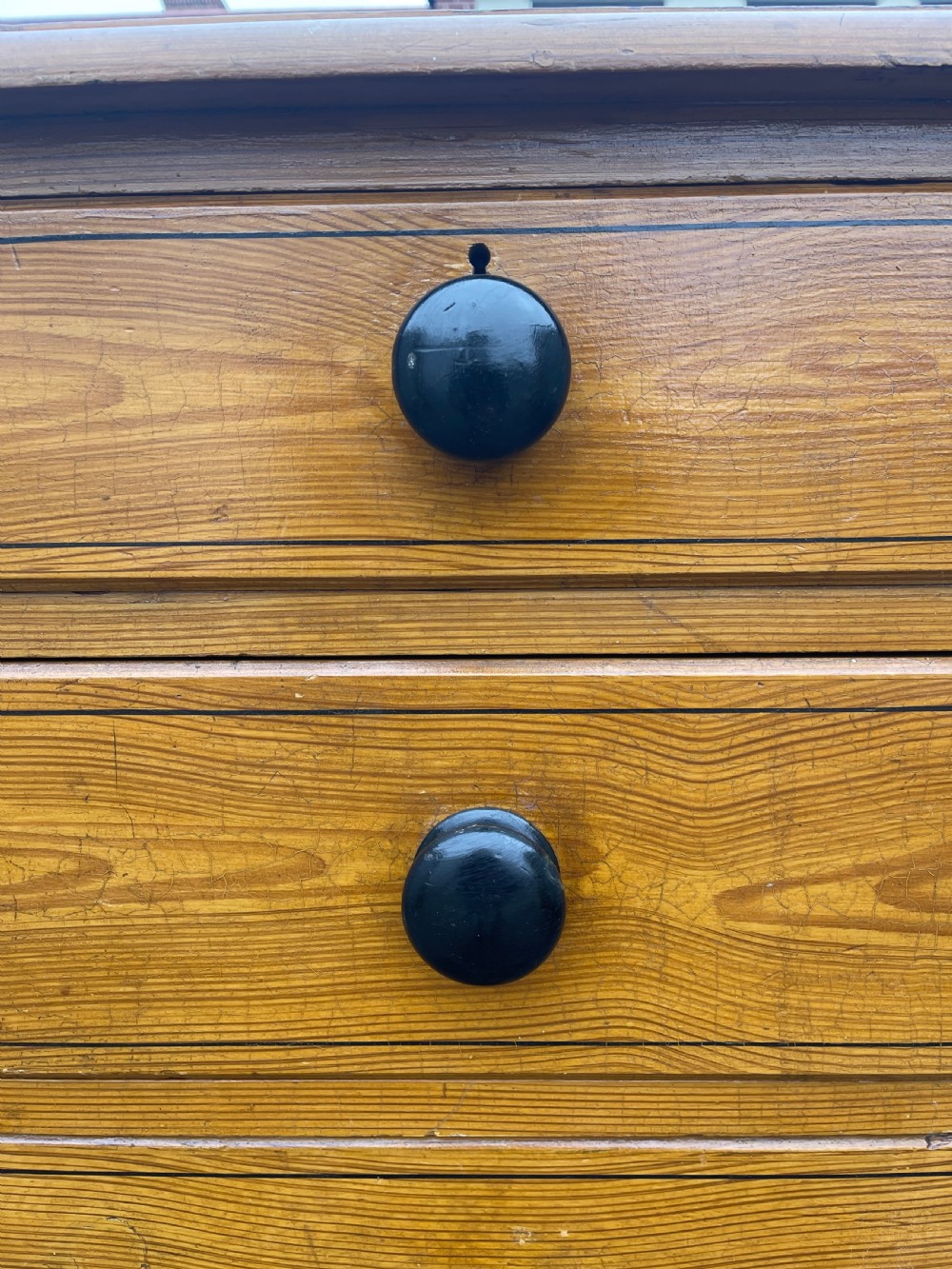 Victorian honey pine chest of drawers featuring two short drawers over three long drawers with dark turned knobs and painted decorative corner accents. View XI