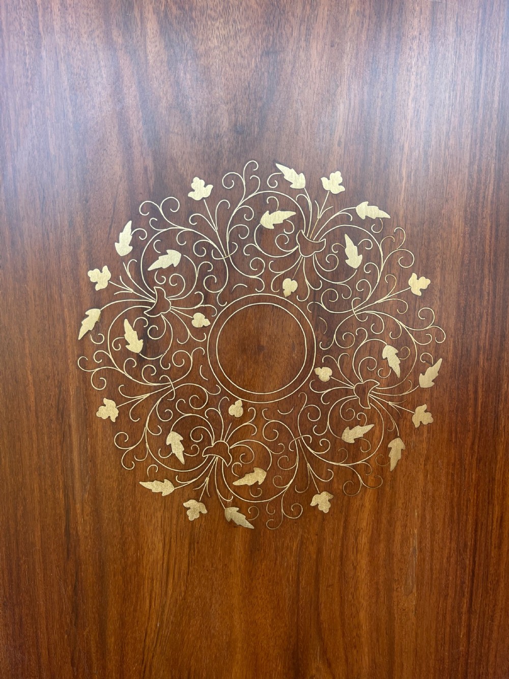 An octagonal warm brown wooden side table with delicate brass wire inlays and pointed arch cut-outs around the base. View III