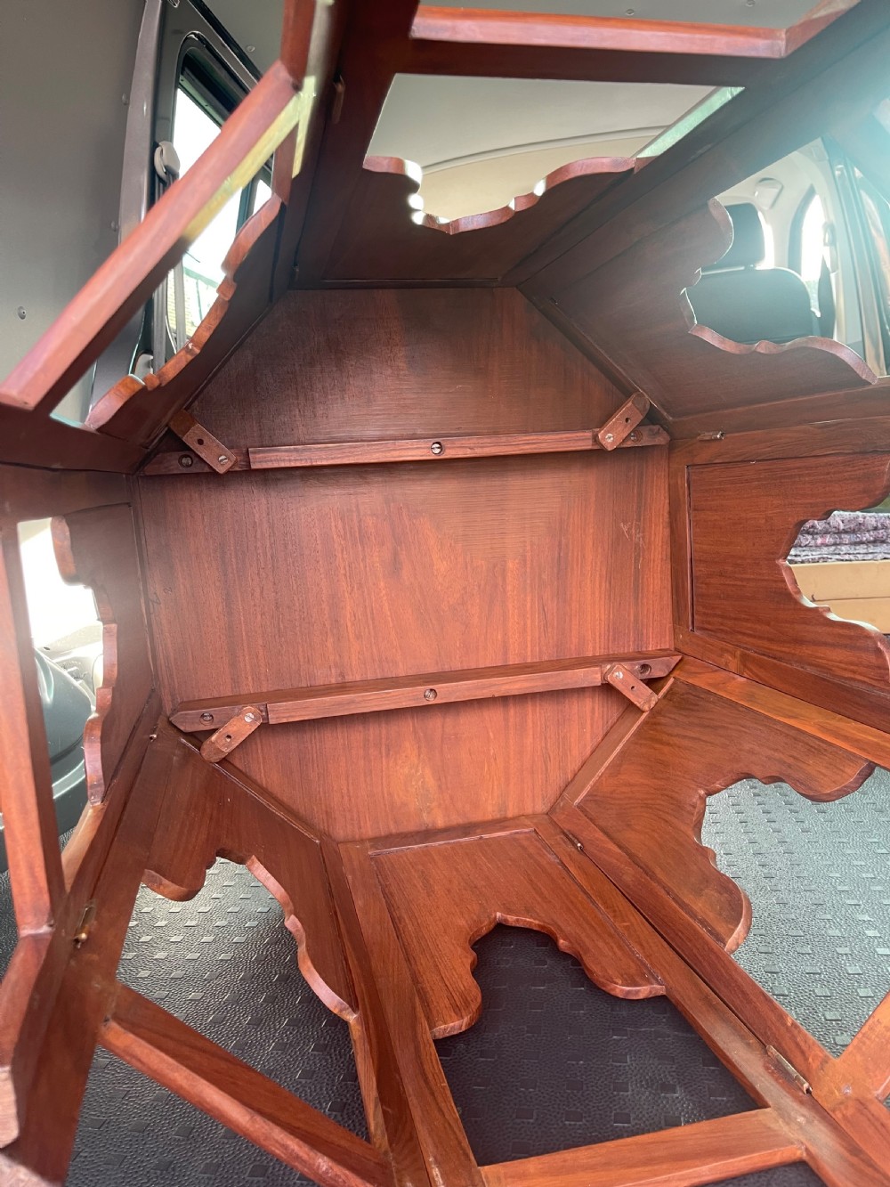 An octagonal warm brown wooden side table with delicate brass wire inlays and pointed arch cut-outs around the base. View IV