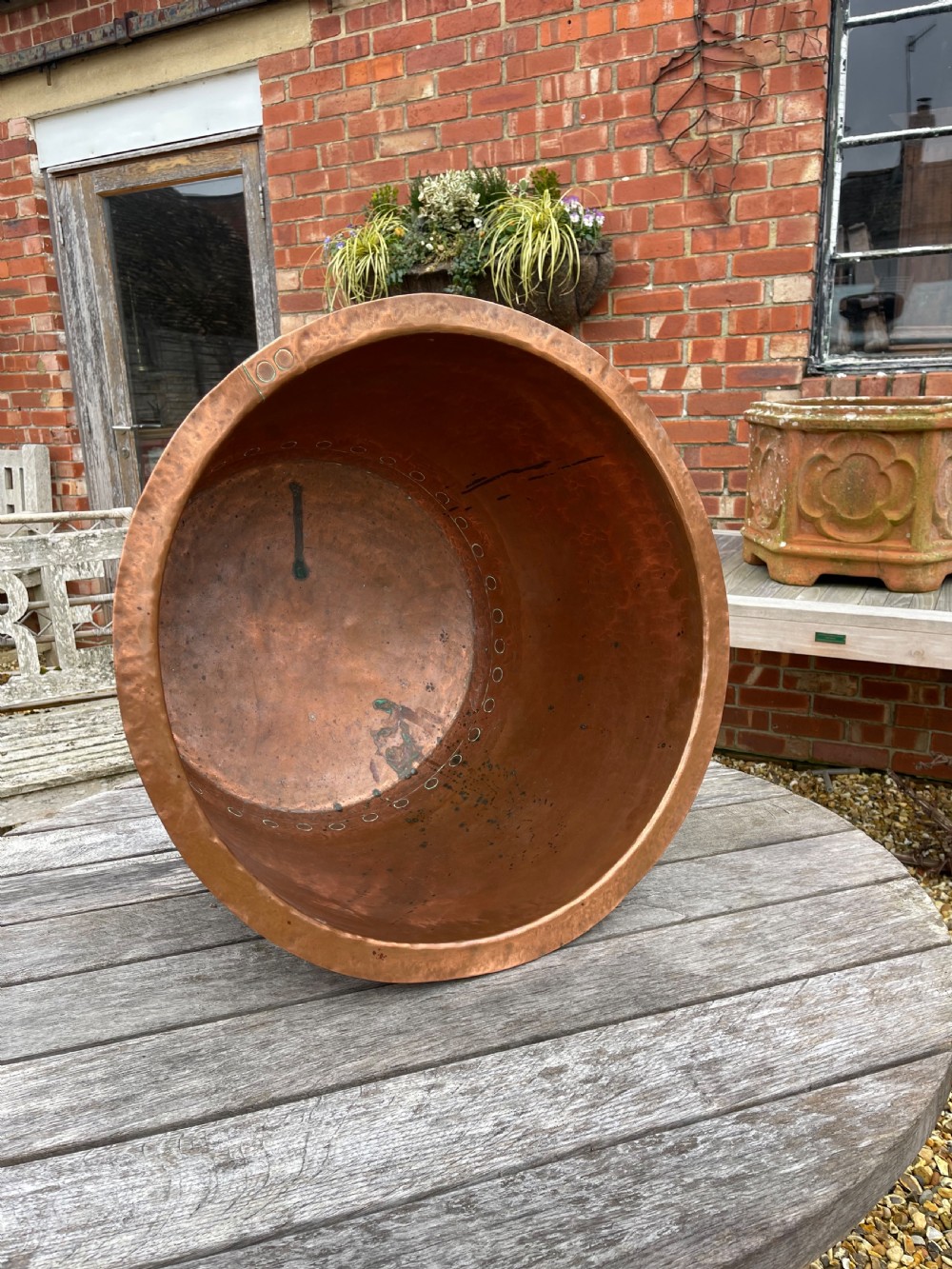 A large nineteenth-century cylindrical copper tub featuring heavy riveted vertical seams and a natural weathered patina. View II