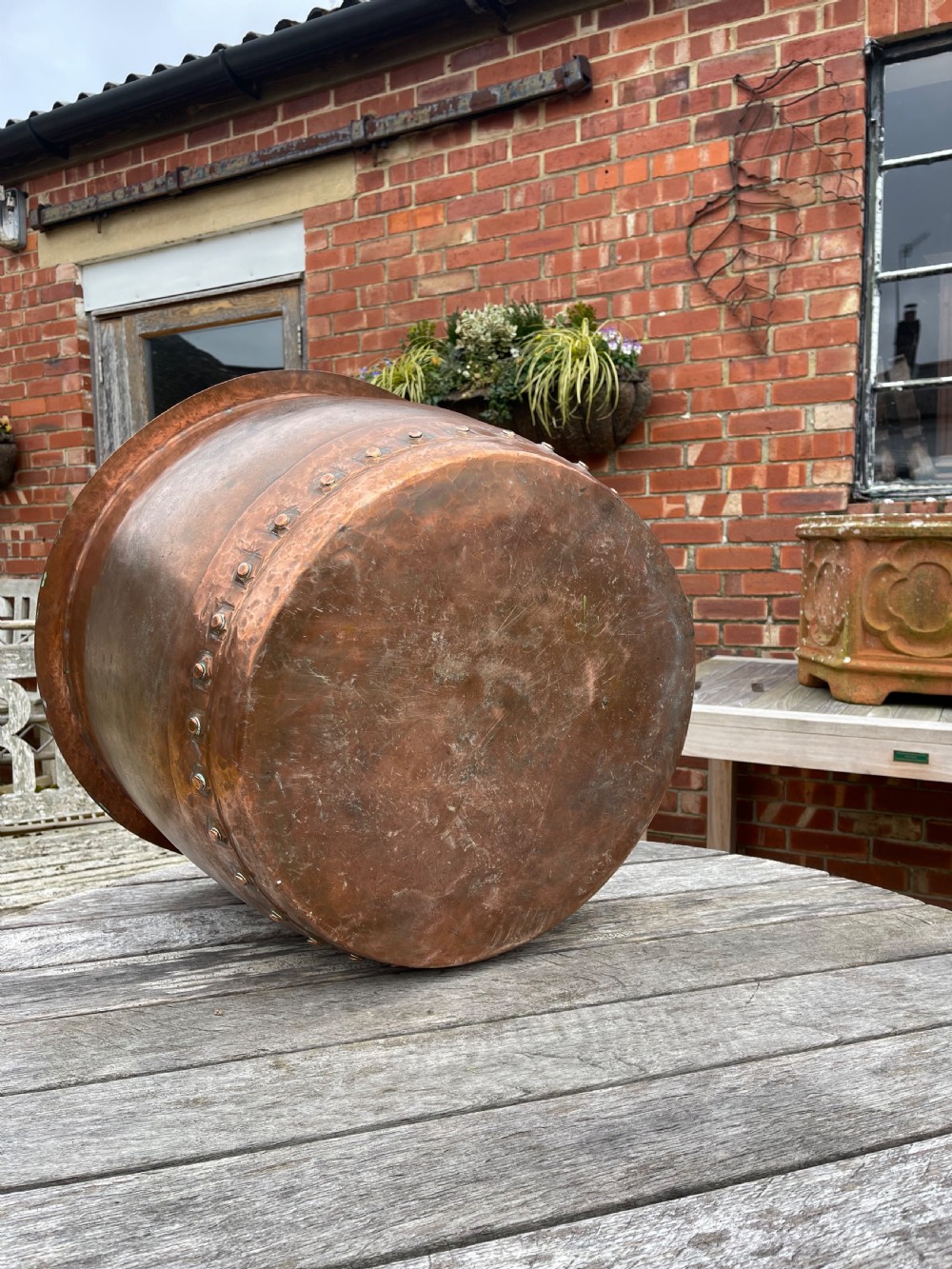 A large nineteenth-century cylindrical copper tub featuring heavy riveted vertical seams and a natural weathered patina. View III