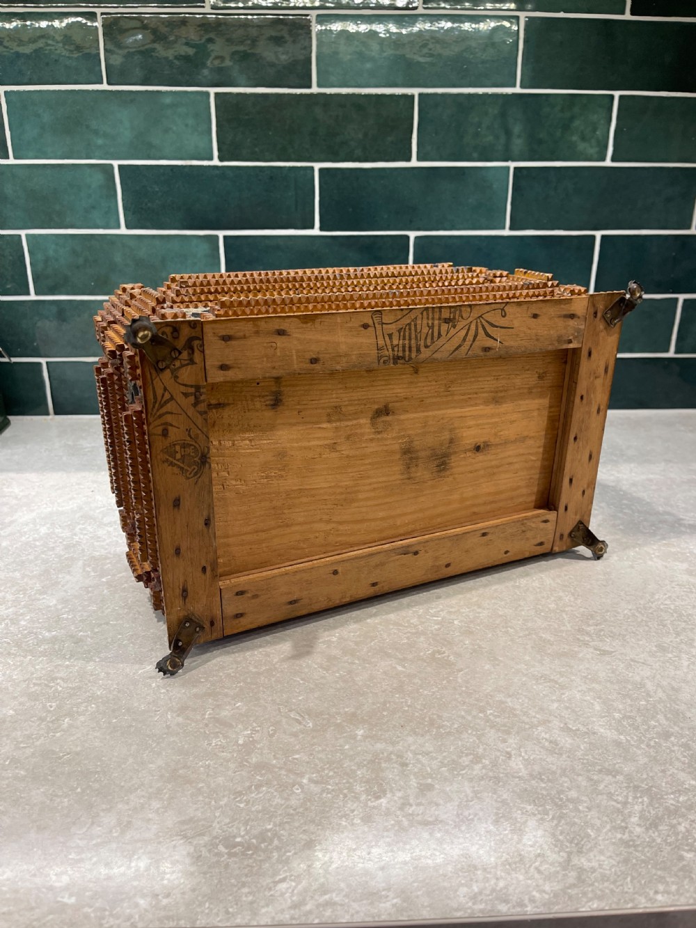 An antique tramp art box featuring layered notch-carved brown wood, dark velvet panels, metal corner mounts, and claw feet. View V