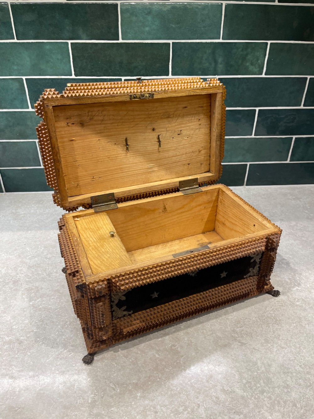 An antique tramp art box featuring layered notch-carved brown wood, dark velvet panels, metal corner mounts, and claw feet. View VI