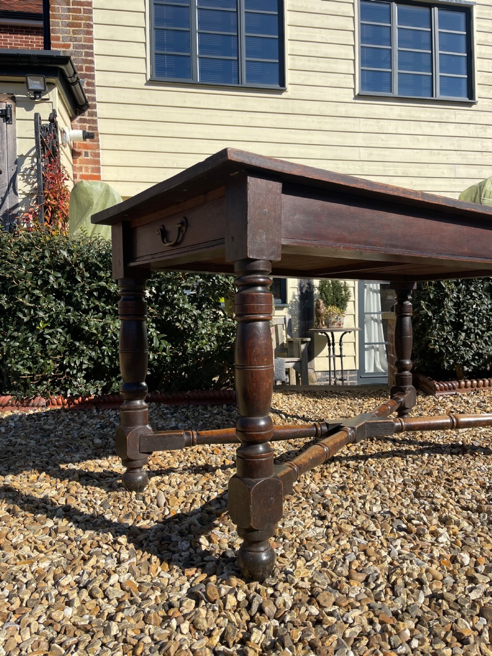 A nineteenth-century rectangular dark oak table featuring turned legs, a turned X-frame stretcher base, and a side drawer. View VIII