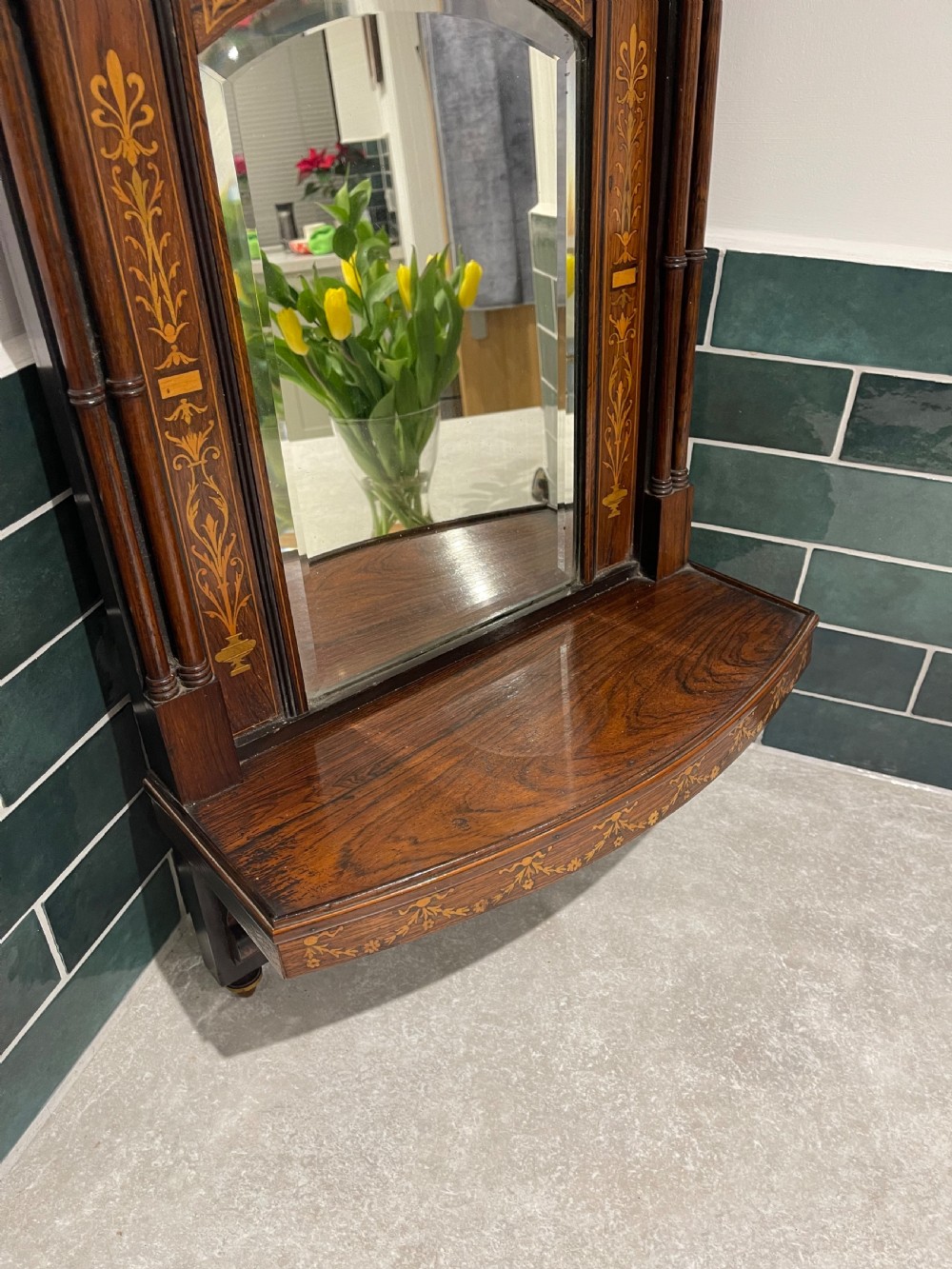A late Victorian dark wood wall shelf featuring marquetry floral inlay, turned side columns, an arched central mirror, and a pierced fretwork apron. View III