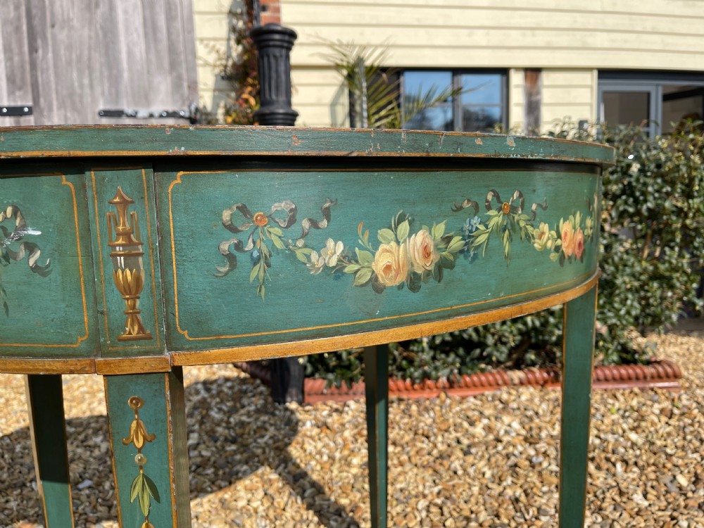 A late Victorian kidney-shaped writing desk finished in green paint with hand-painted floral swags and an inset leather top. View II