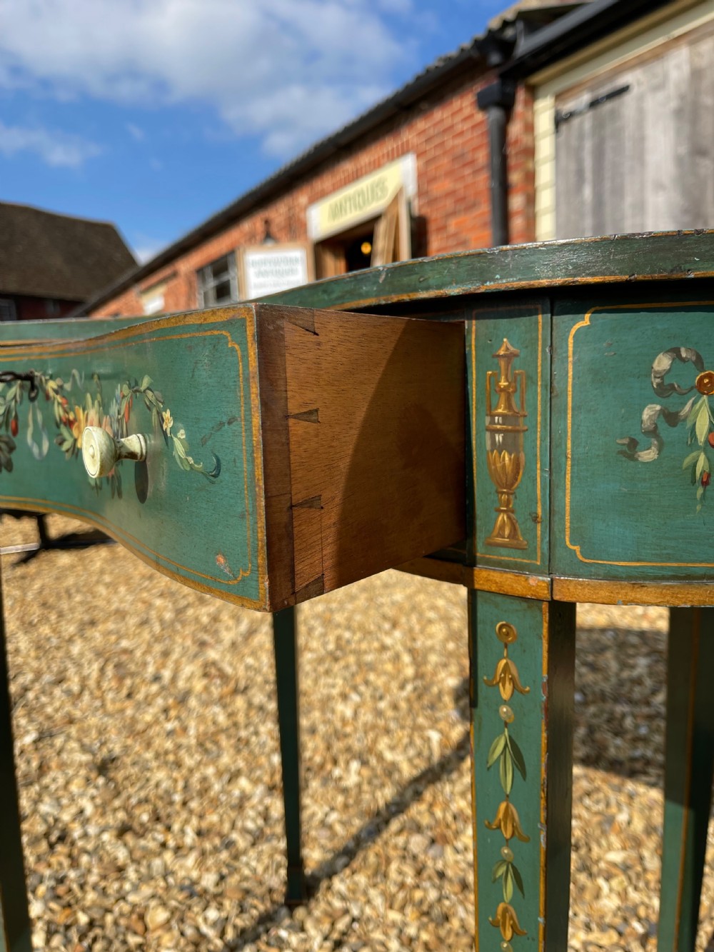 A late Victorian kidney-shaped writing desk finished in green paint with hand-painted floral swags and an inset leather top. View VII