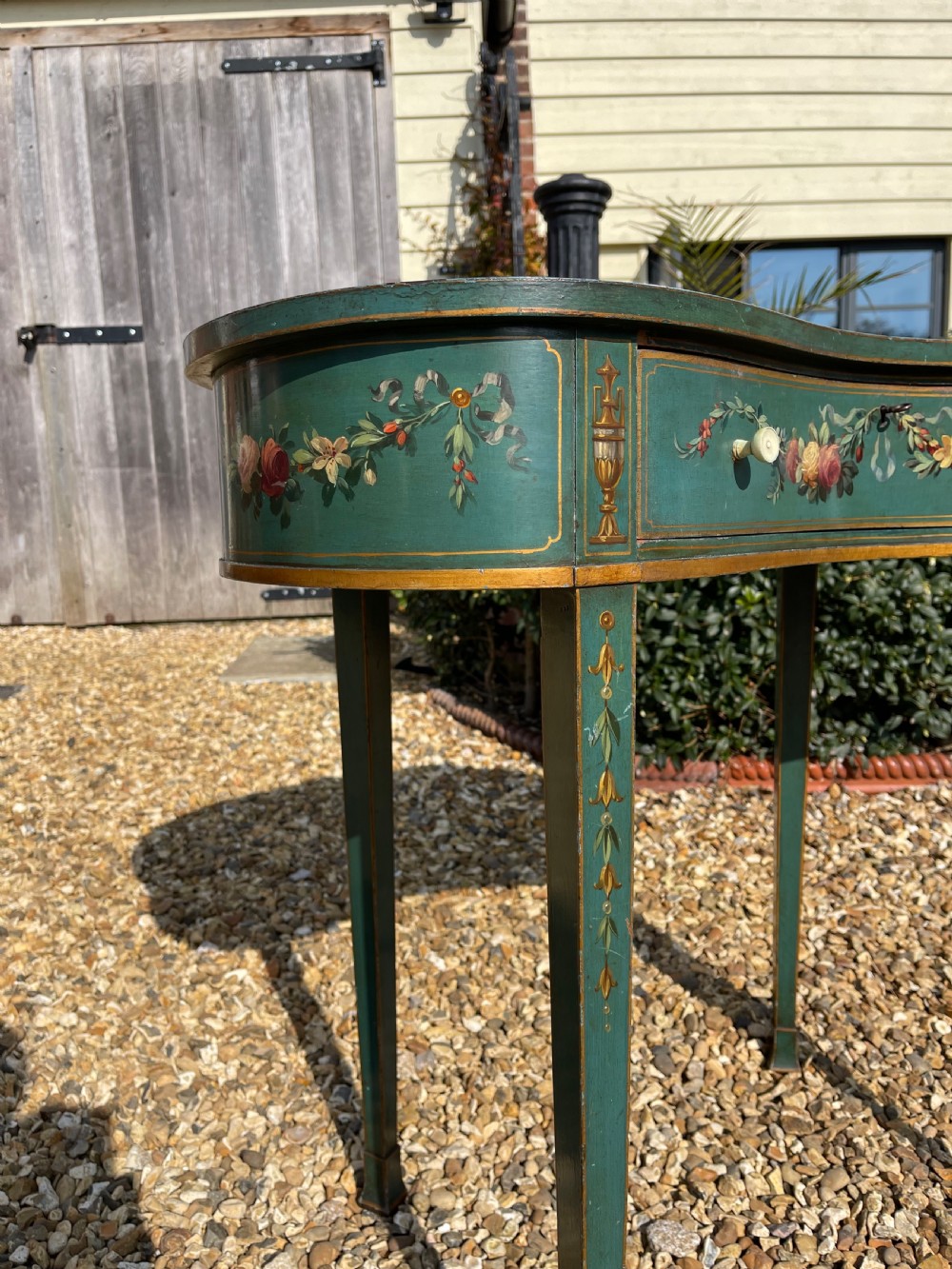 A late Victorian kidney-shaped writing desk finished in green paint with hand-painted floral swags and an inset leather top. View VIII