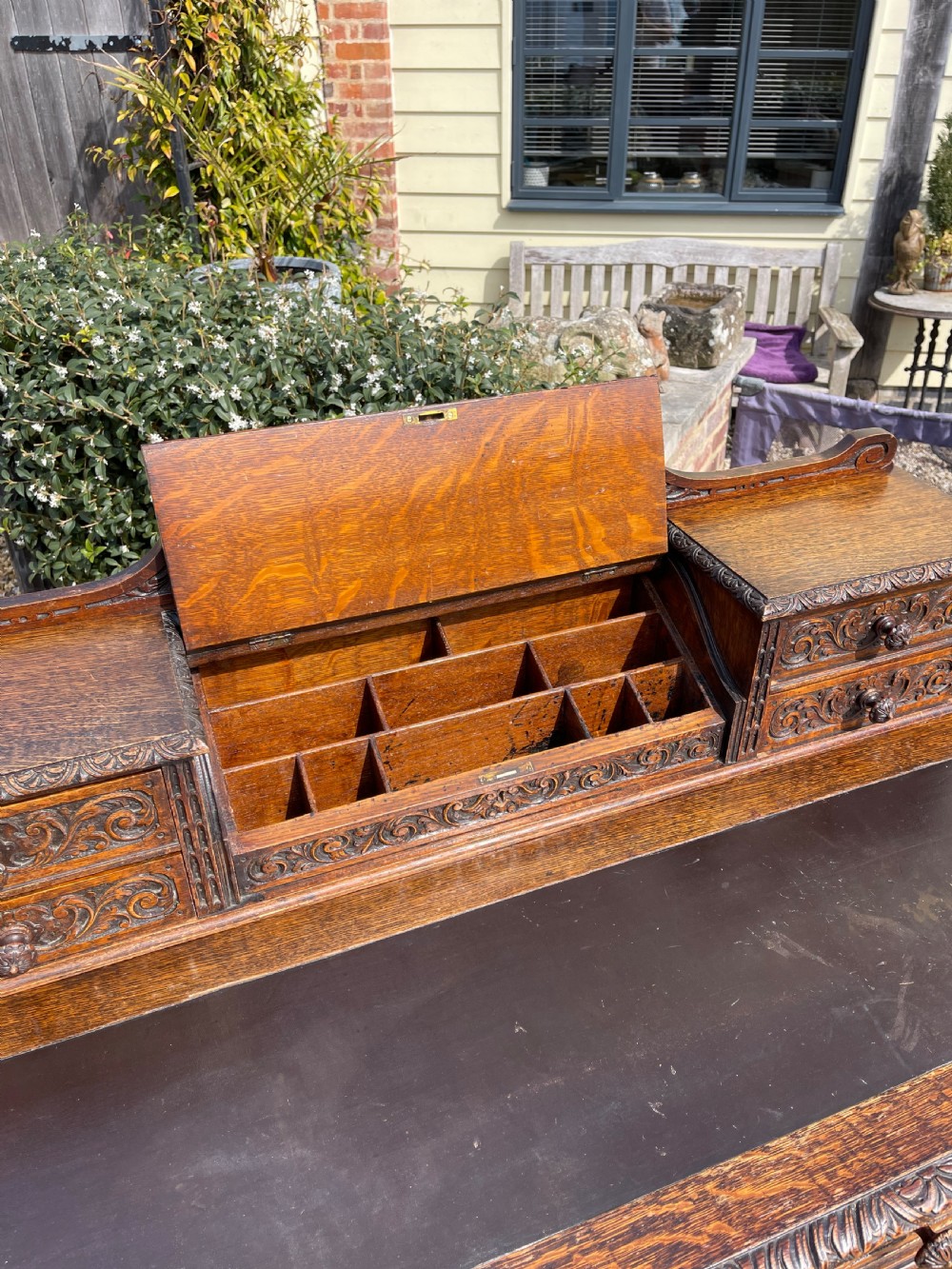 A late Victorian dark oak pedestal desk featuring intricate relief carving across all drawer fronts and a detailed raised superstructure. View VIII