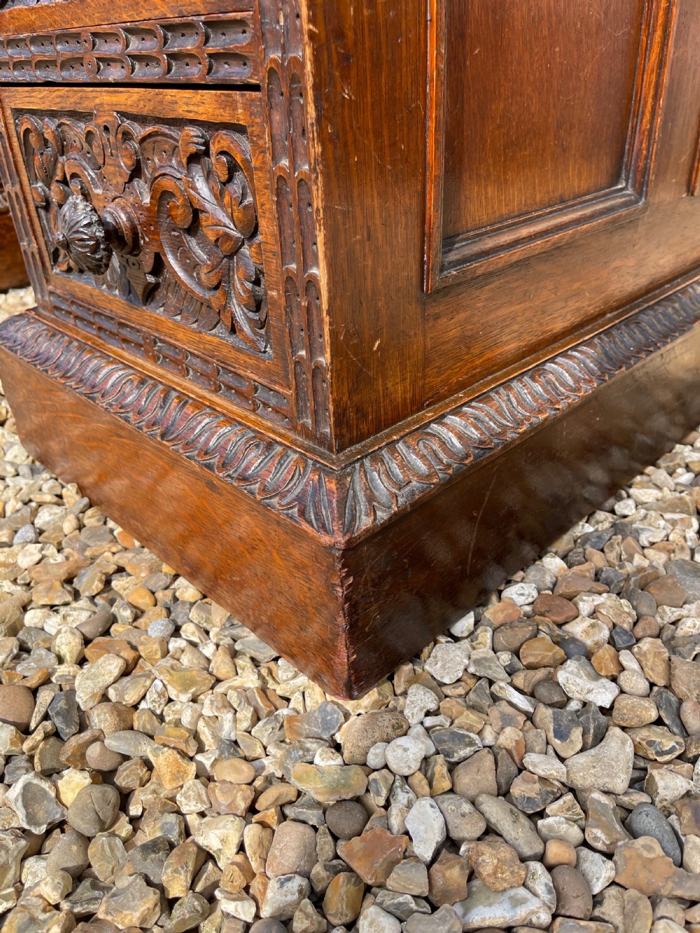 A late Victorian dark oak pedestal desk featuring intricate relief carving across all drawer fronts and a detailed raised superstructure. View IX