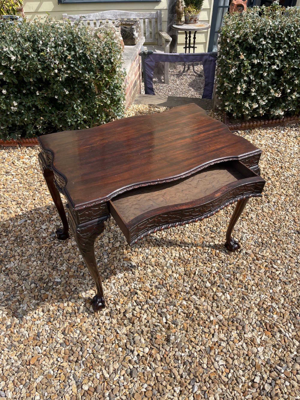 A dark mahogany Chippendale style side table featuring carved ball-and-claw feet, carved knees, and a blind fretwork apron. View X