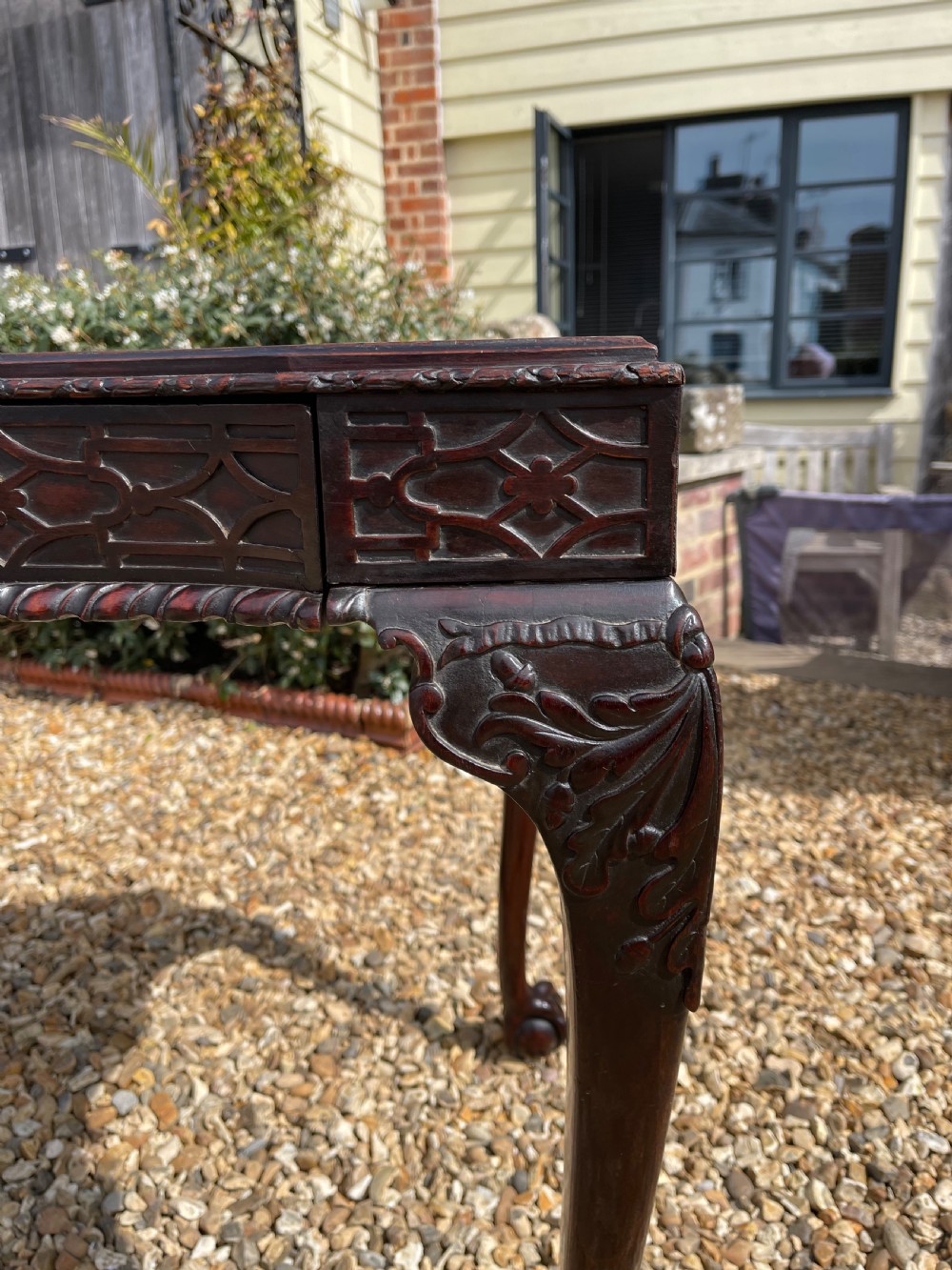 A dark mahogany Chippendale style side table featuring carved ball-and-claw feet, carved knees, and a blind fretwork apron. View XI