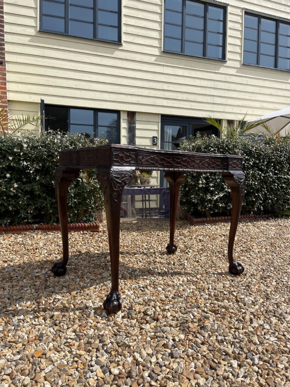 A dark mahogany Chippendale style side table featuring carved ball-and-claw feet, carved knees, and a blind fretwork apron. View XII