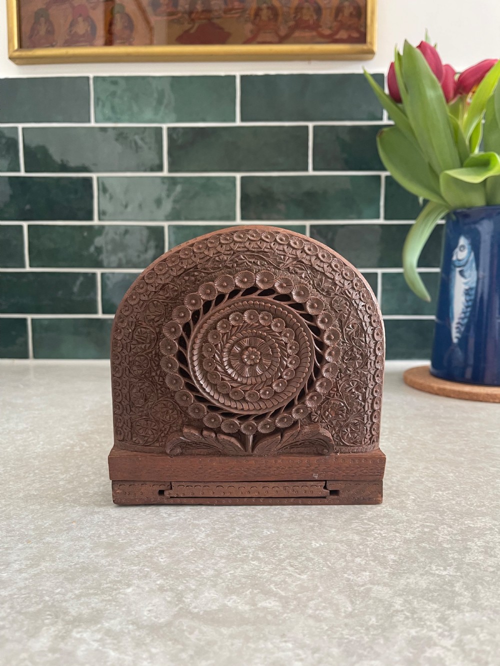 An antique carved warm brown wooden expandable book slide with intricate floral relief carving on arched folding end panels. View II