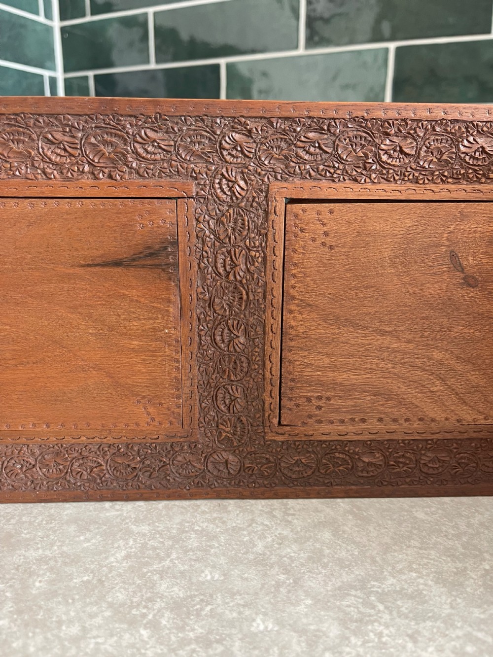 An antique carved warm brown wooden expandable book slide with intricate floral relief carving on arched folding end panels. View IV