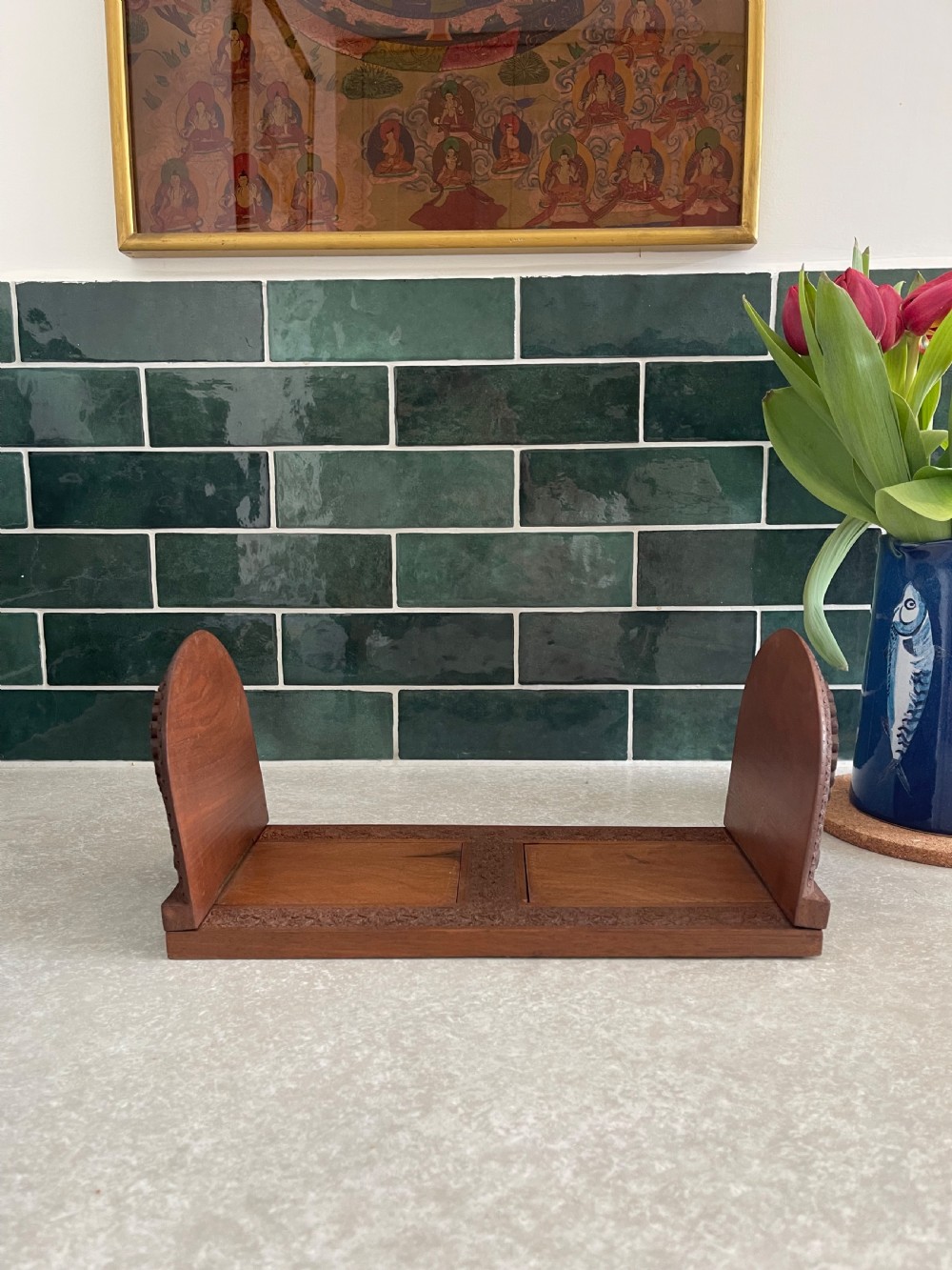 An antique carved warm brown wooden expandable book slide with intricate floral relief carving on arched folding end panels. View V