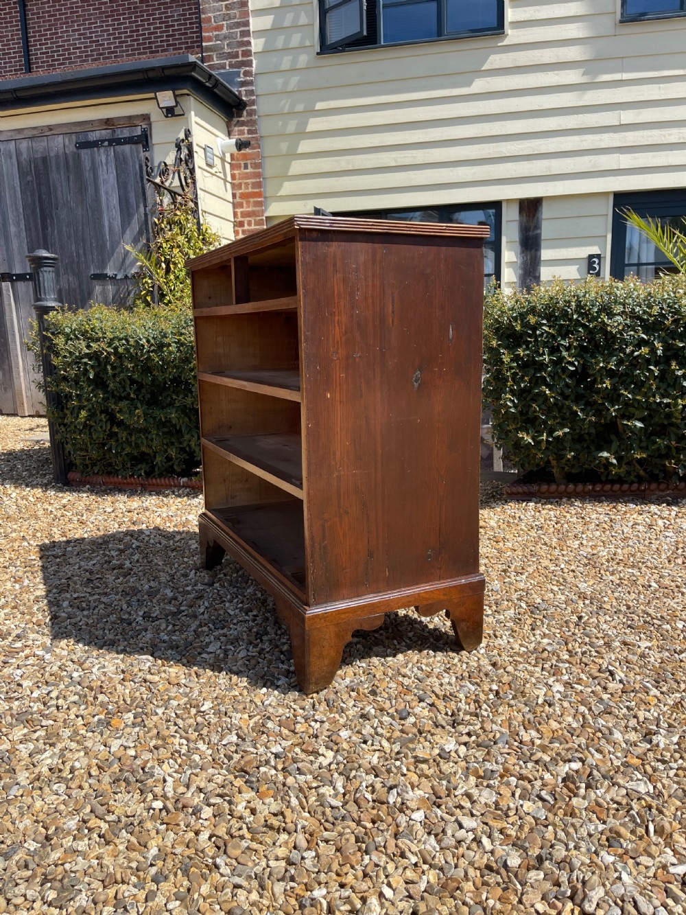 A George III wooden chest of drawers featuring two short drawers over three long graduated drawers, fitted with brass handles and supported on bracket feet. View VIII