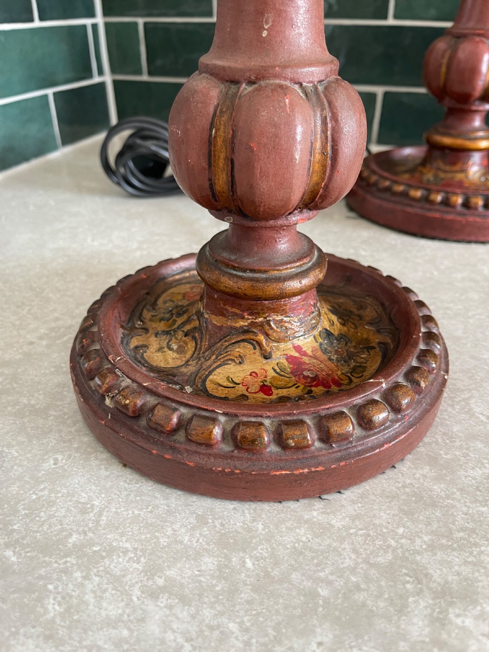 A pair of tall Italian carved wooden candlestick table lamps decorated with terracotta red paint, gold leaf accents, and faux candle sleeves. View II